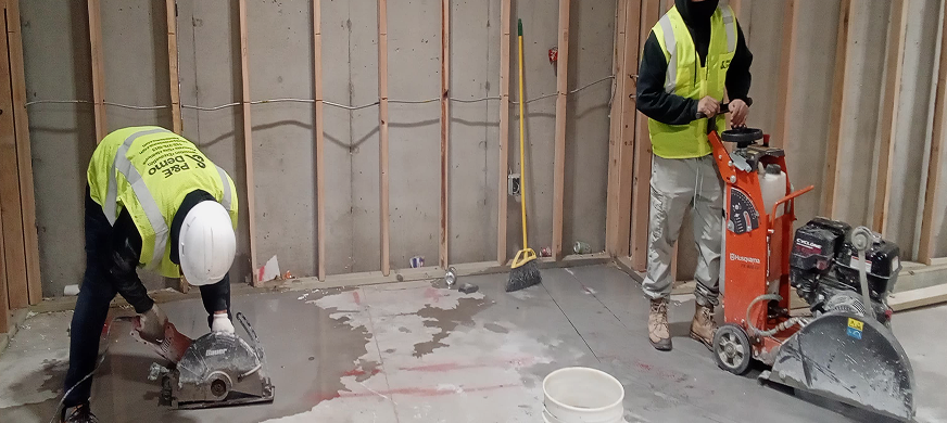 Two demolition contractors using handheld and walk‑behind concrete saws during precision concrete cutting services in New Jersey