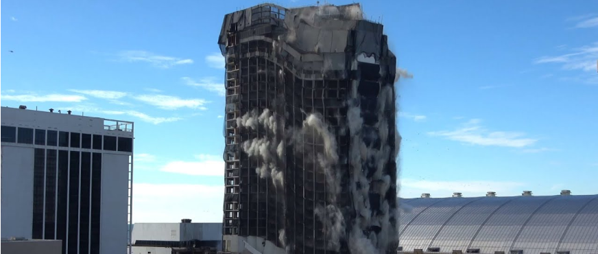 Controlled demolition of tall building collapsing inward with dust and debris during professional demolition services in New Jersey.