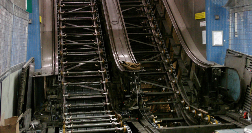 Escalators dismantled with exposed mechanical framework, rollers, and chains during professional escalator removal services in New Jersey.
