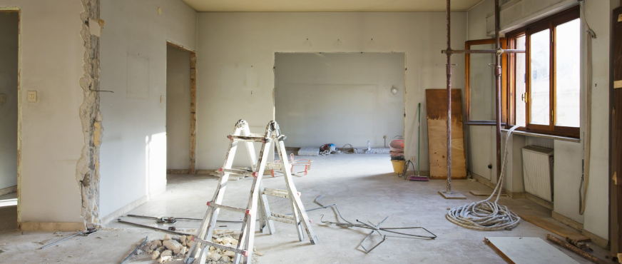 Interior demolition site in New Jersey showing exposed walls, construction tools, and an unfinished floor during a renovation project