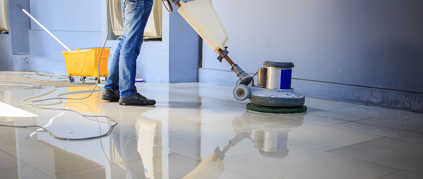Worker operating industrial floor polishing machine during professional floor stripping and surface preparation services in New Jersey