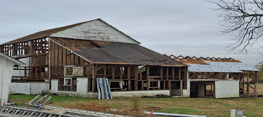 Partially deconstructed commercial building with exposed wooden framing and roof sections removed during professional floor removal services across New Jersey.