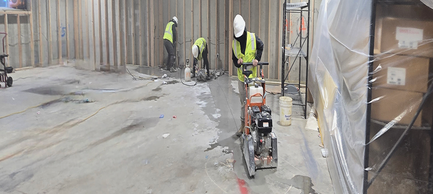 Workers using concrete saw and demolition equipment to cut and remove interior concrete slab during professional slab removal services in New Jersey.