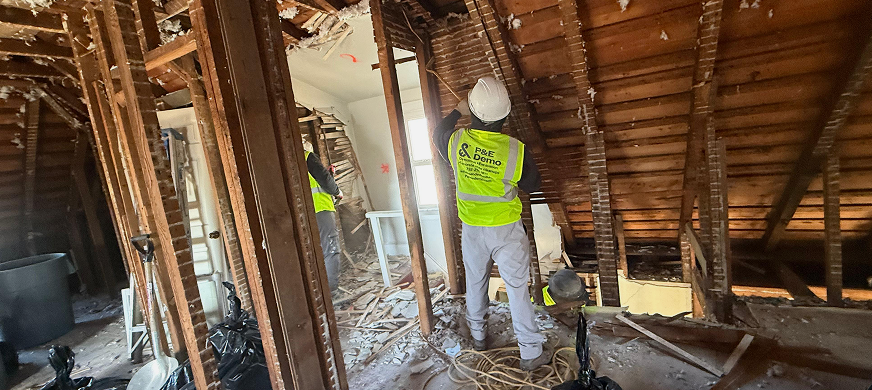 Demolition contractors in safety gear dismantling interior walls during professional wall removal services in New Jersey
