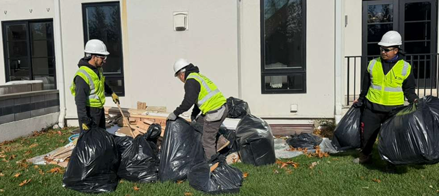 NJ demolition crew in safety gear handling debris bags during a property cleanout, ensuring safe and organized junk removal